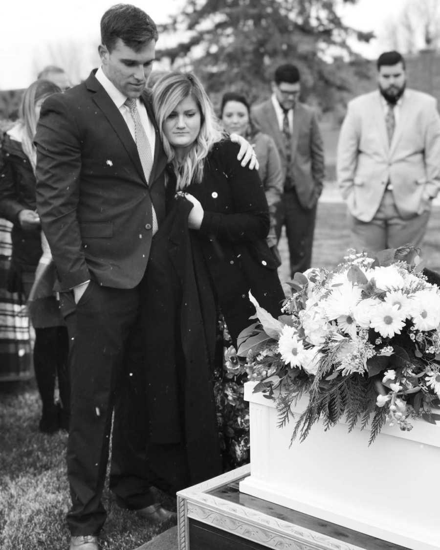 Mother and Father arm in arm at funeral for their baby