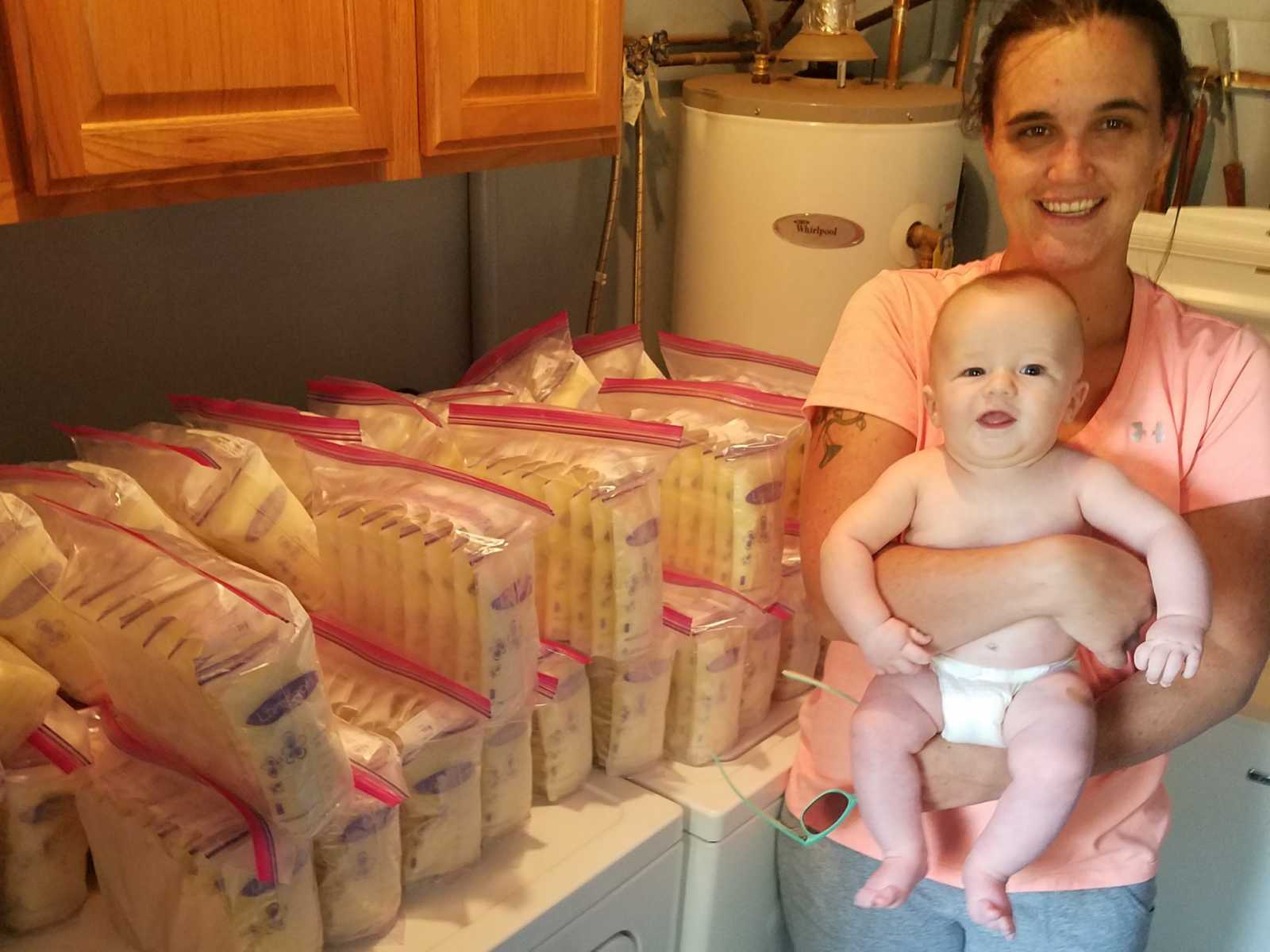 Mother holding baby besides stacks of ziploc bags containing breastmilk she is donating