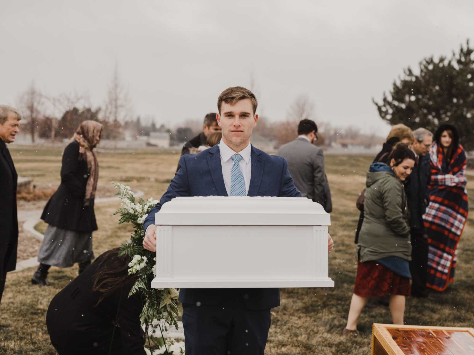 Father holds casket at his baby daughter's funeral