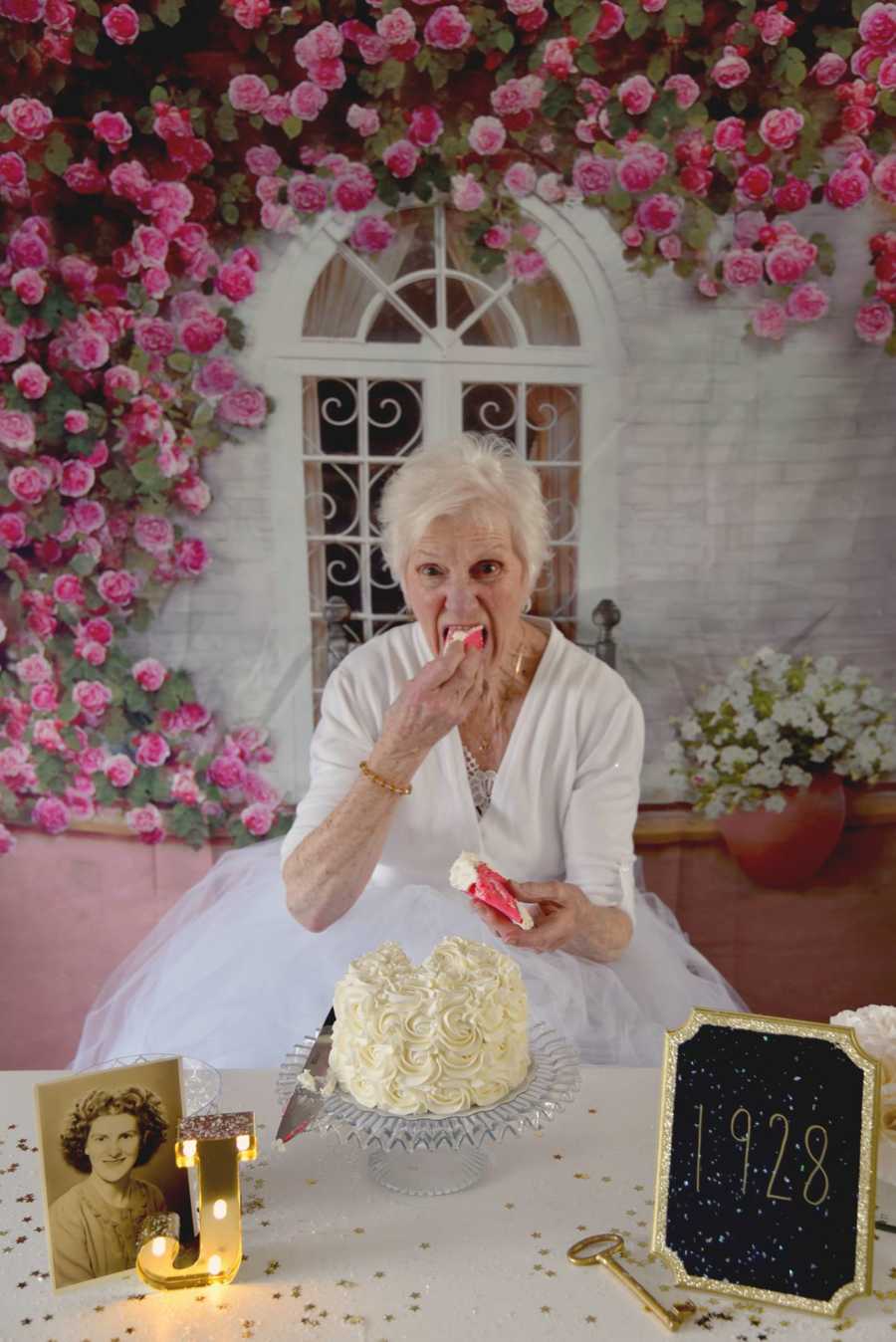 90 year old woman takes bite of birthday cake with her hands