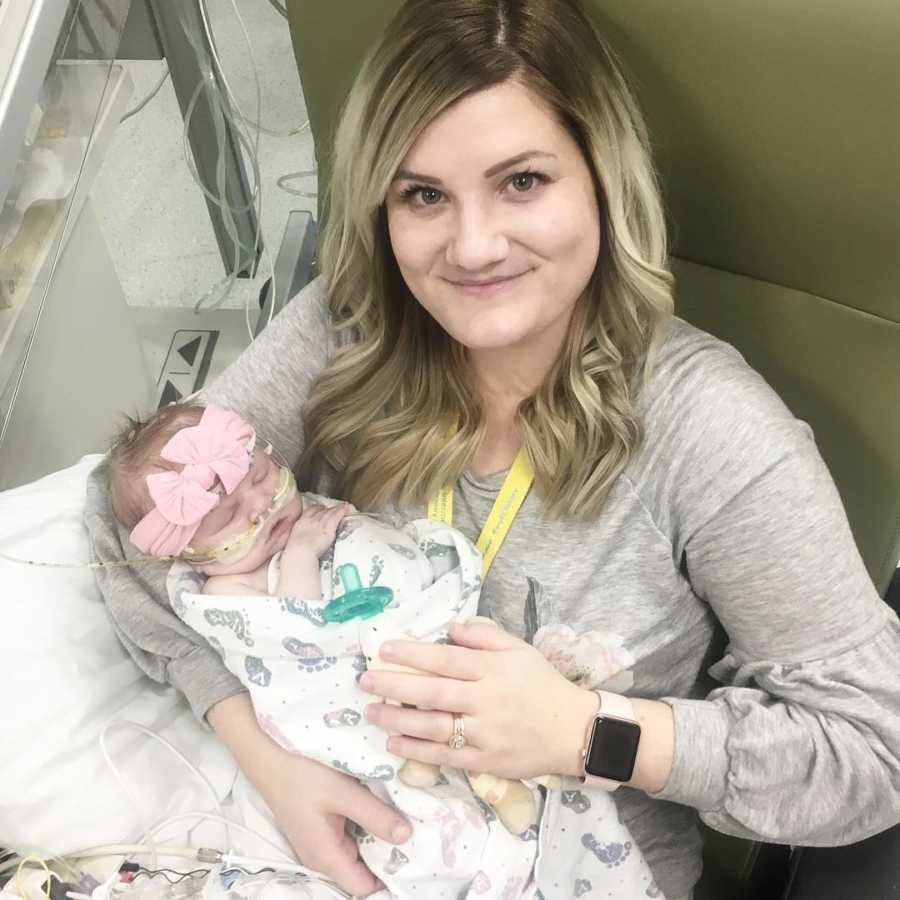 Mother holding newborn who is hooked up to IV's