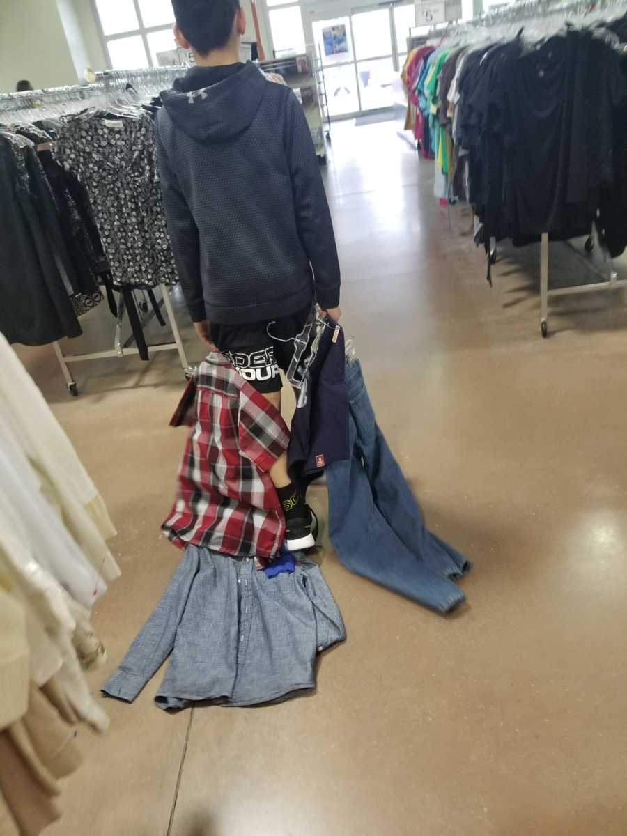 Entitled son drags clothes across floor at Goodwill