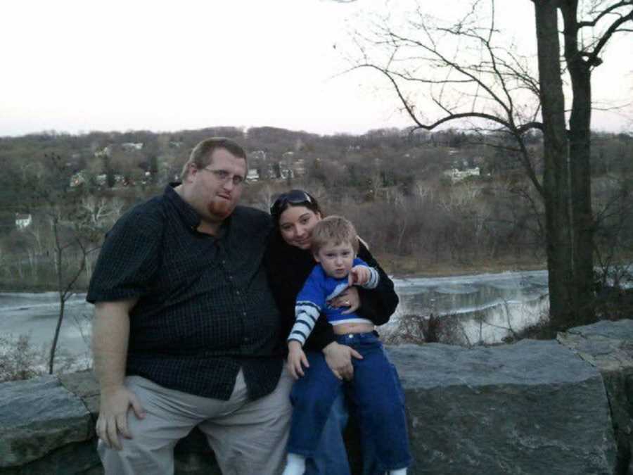 500 pound man sit on rock ledge with wife and son with autism