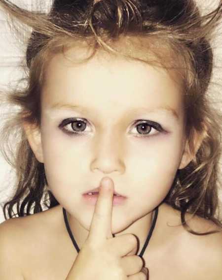 Toddler who is always being told to be quiet holds finger over her mouth