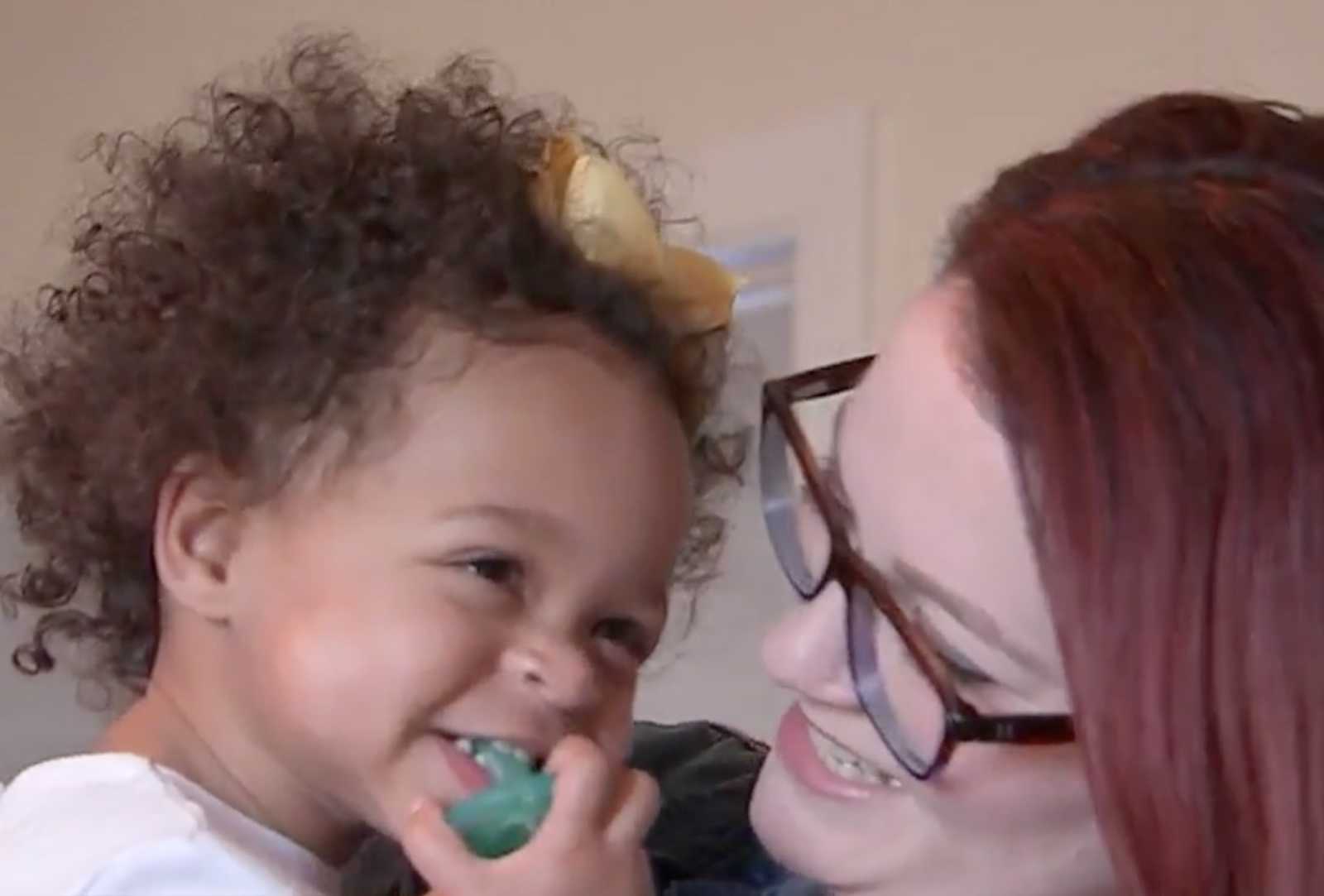 Mom smiles while holding adopted daughter who was once abused