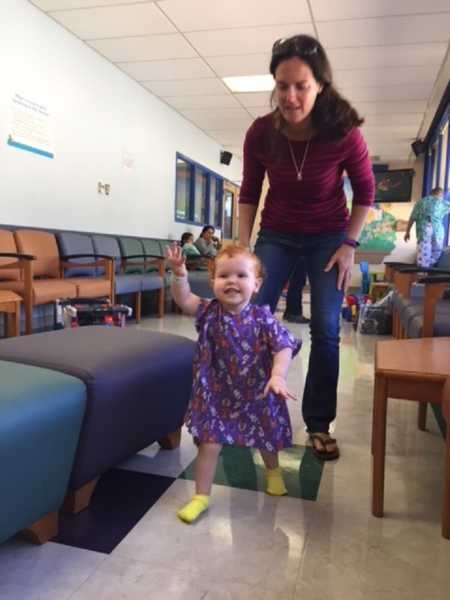 Mother follows toddler in waiting room who needs open heart surgery