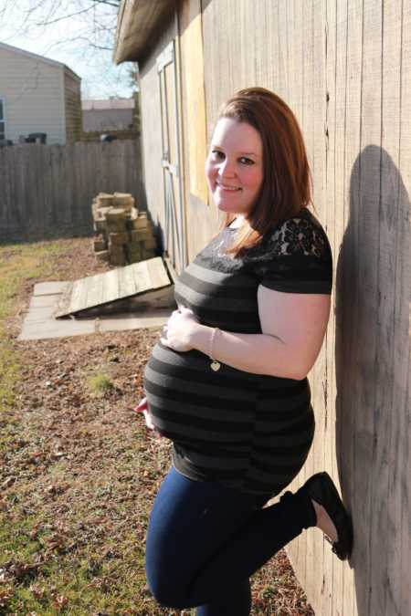 Overweight bride who lost weight pregnant leaning against wall