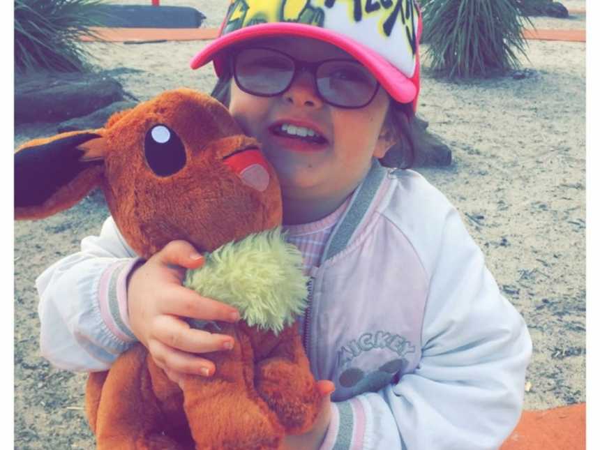 Little girl who had brain surgery smiles while holding on to stuffed animal