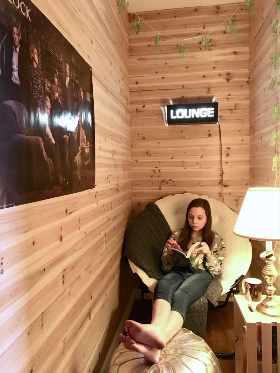 Daughter sitting in chair reading in secret room inside closet her mother made 