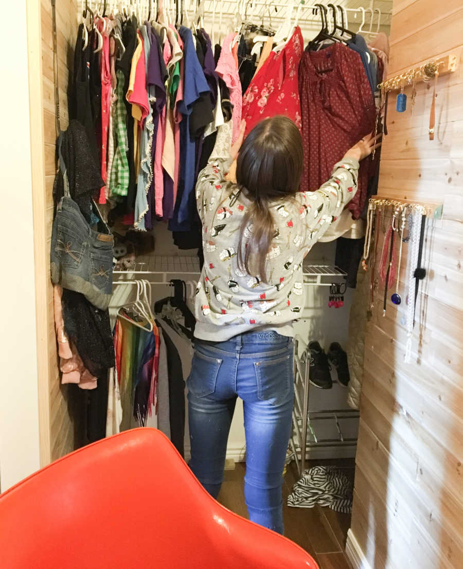 Daughter sifting through clothes in her secret room in closet mother made