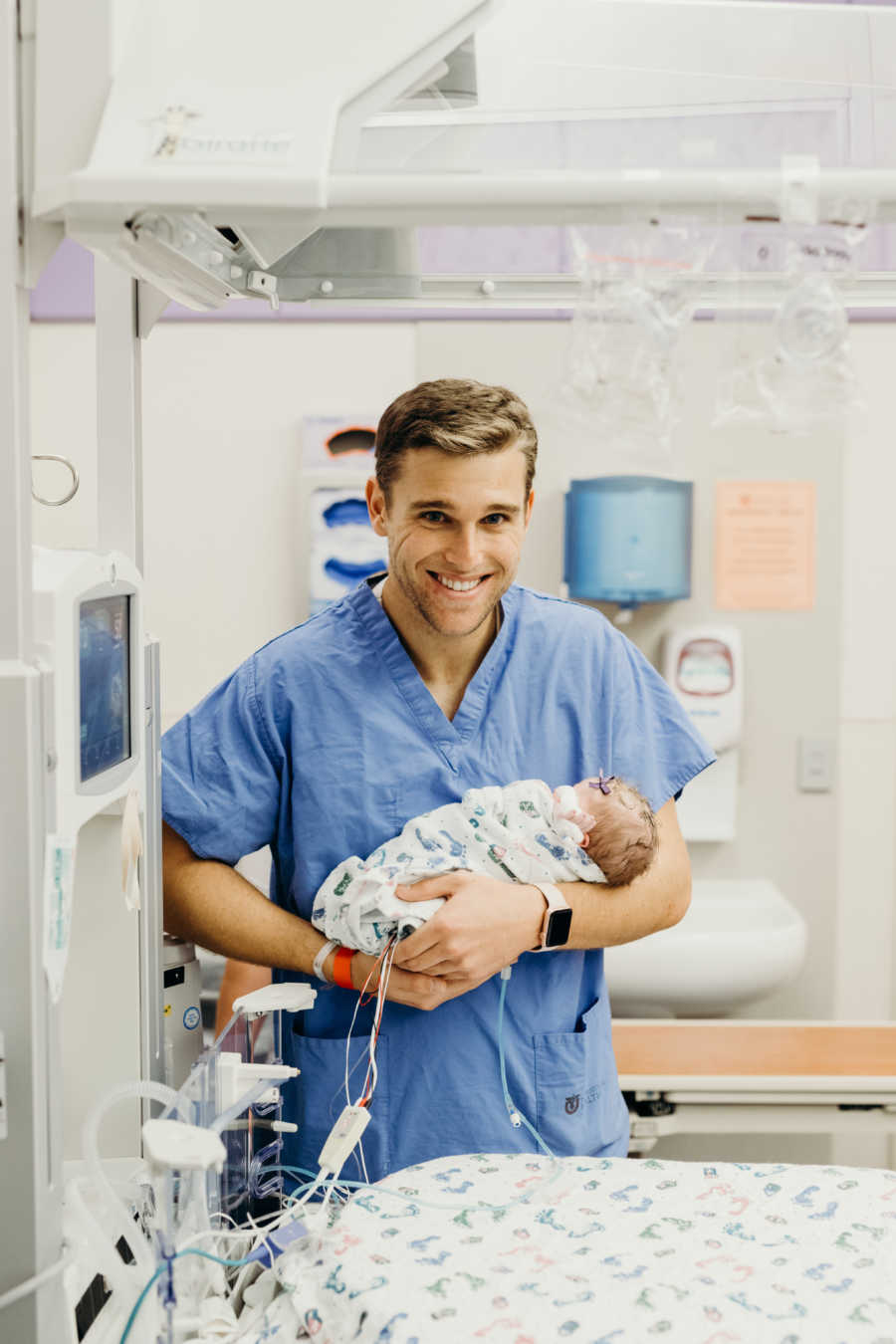 Father holds newborn in NICU