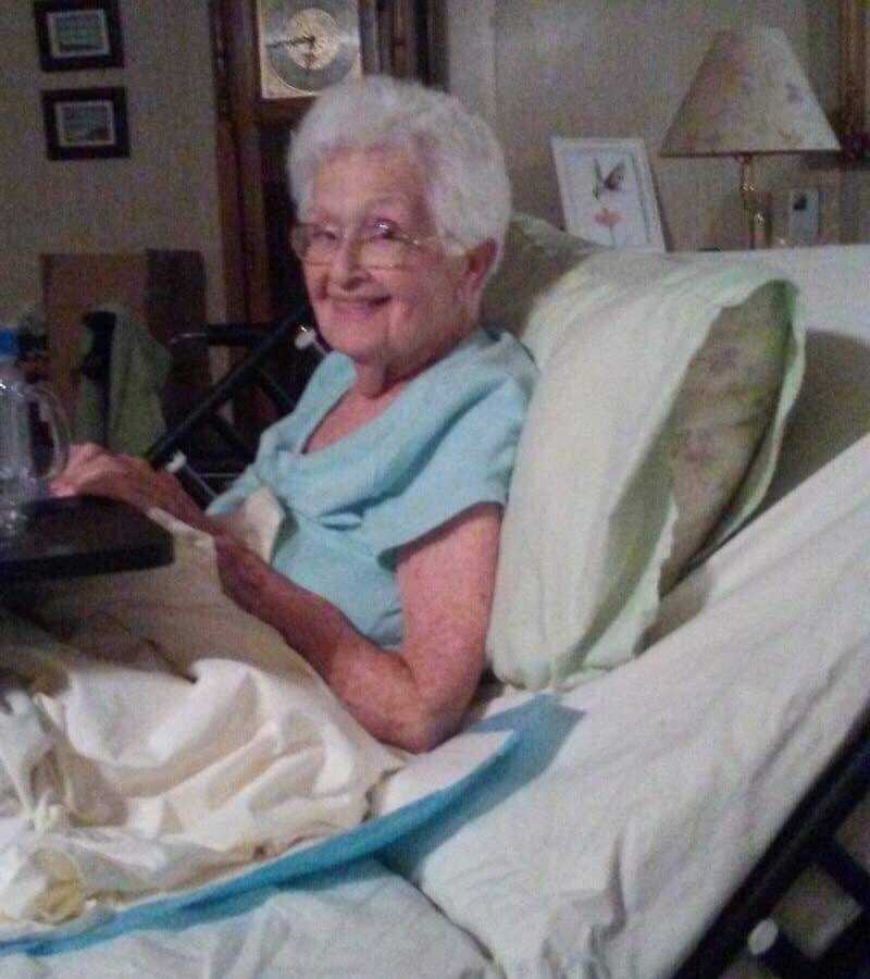 97 year old woman smiling in bed in her home