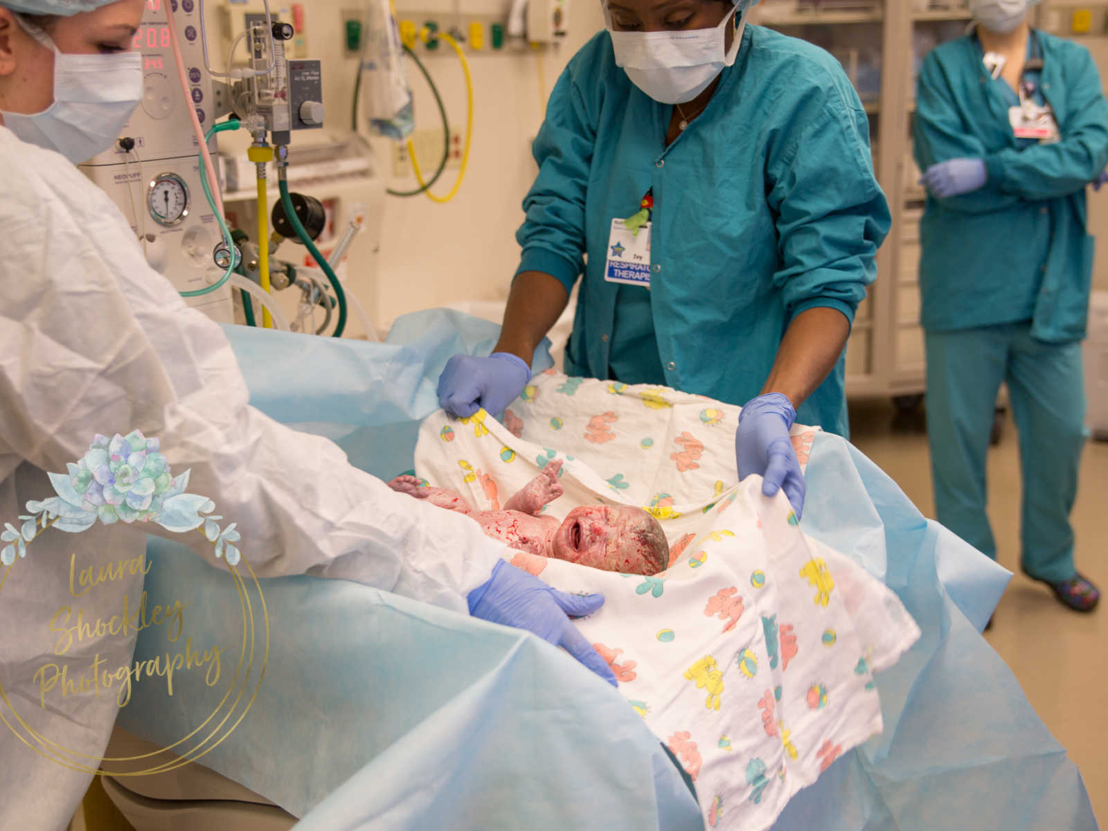 Doctors wrap newborn baby in blanket after c-section