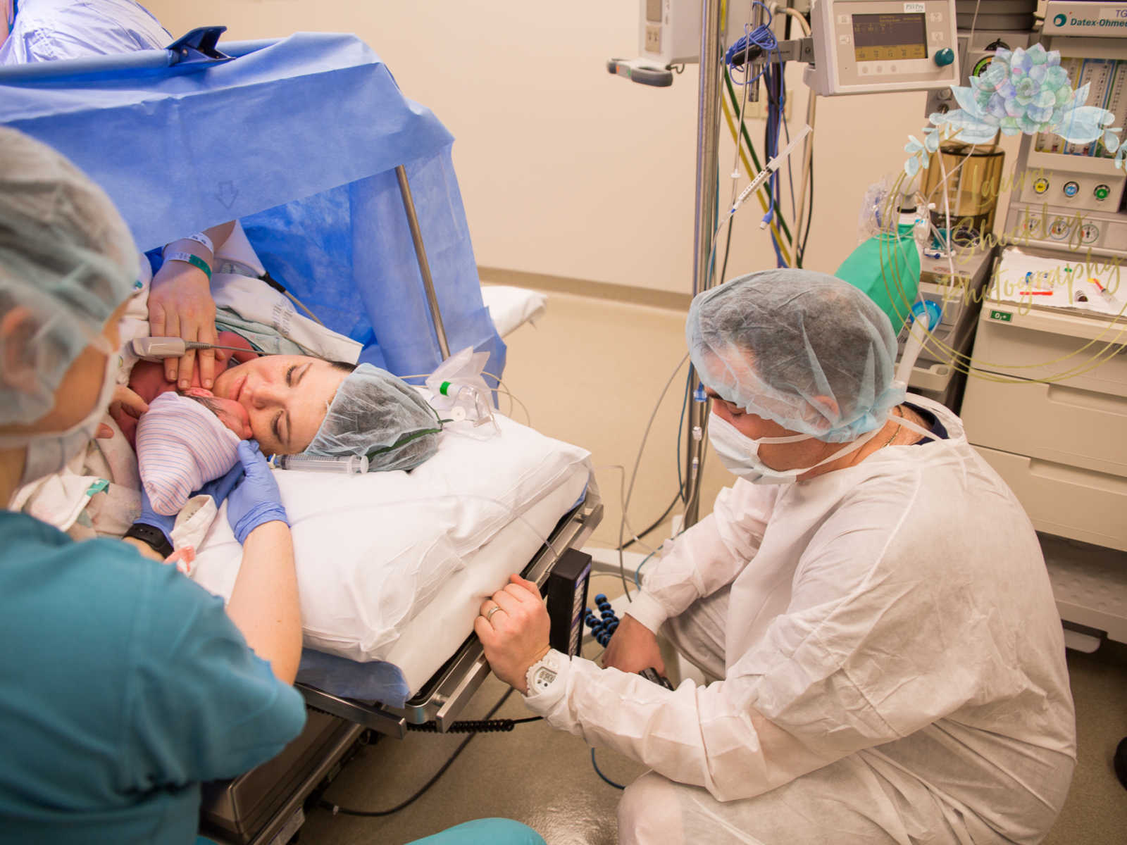 Mother who was in labor for four days lays with bay on her chest while husband squats down behind her