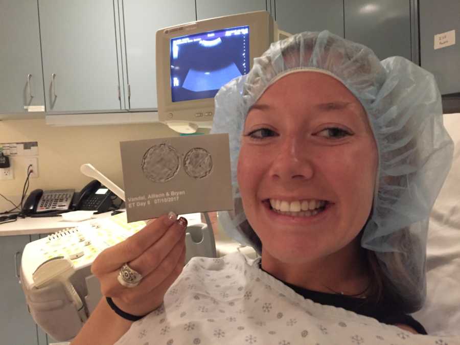 Woman holds up ultrasound after battling with fertility issues