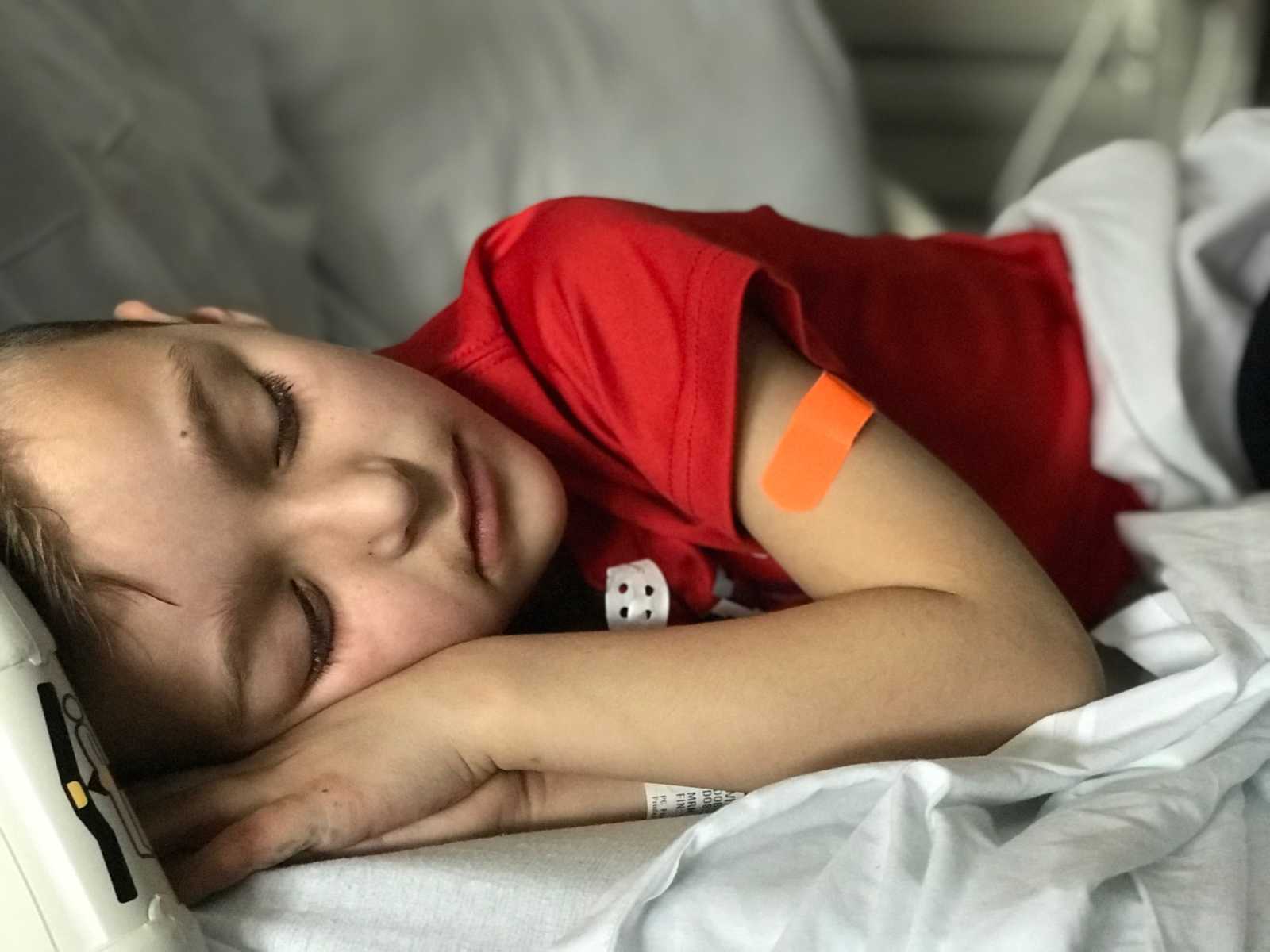 Little boy with leg tumor asleep in hospital bed
