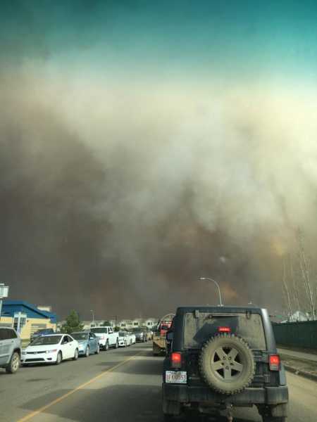 Smoke from wildfires covering the air above cars driving