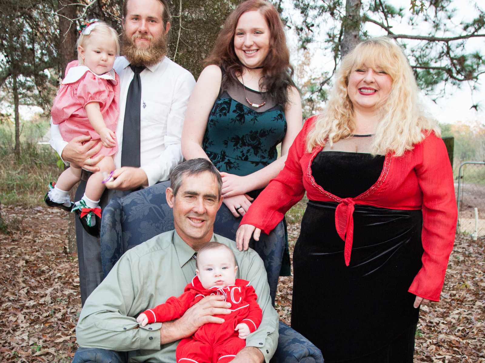 Wife and mother who suffers from diabetes smiles next to family members in the woods