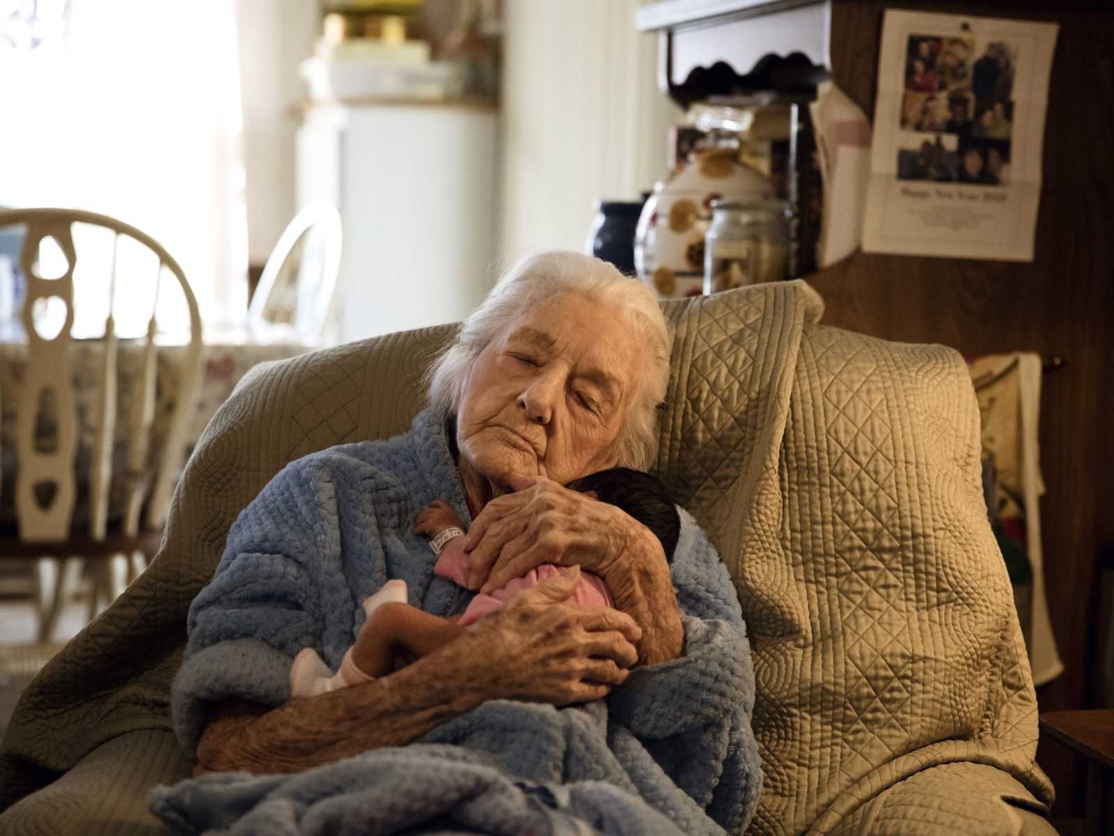 92 year old woman holds newborn baby who is her name sake close to her chest