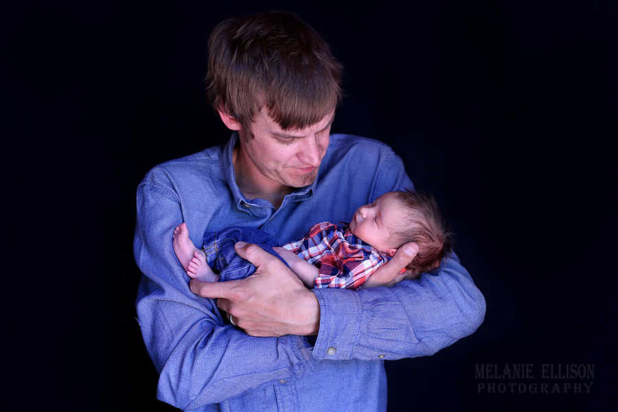 Father who delivered son barehanded looks down at son in his arms