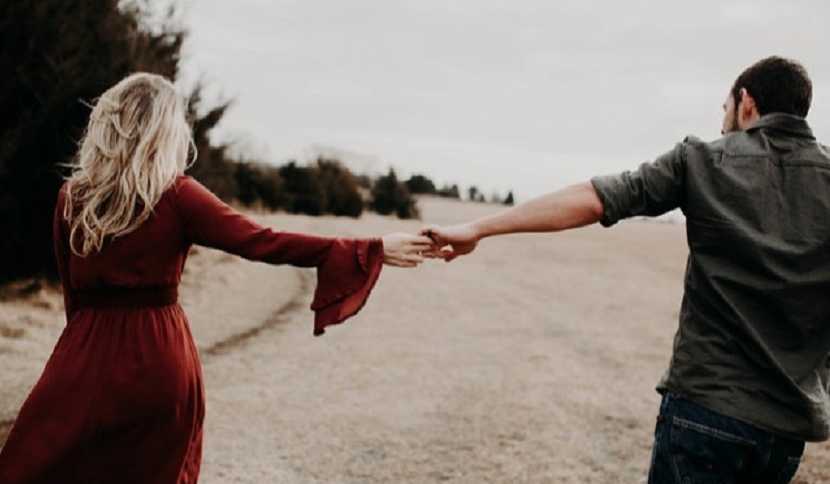 View from the back of husband and wife holding hands after miscarriage