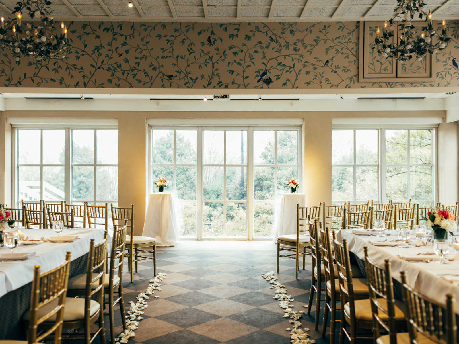 Wedding ceremony set up inside with flowers down either side of the aisle