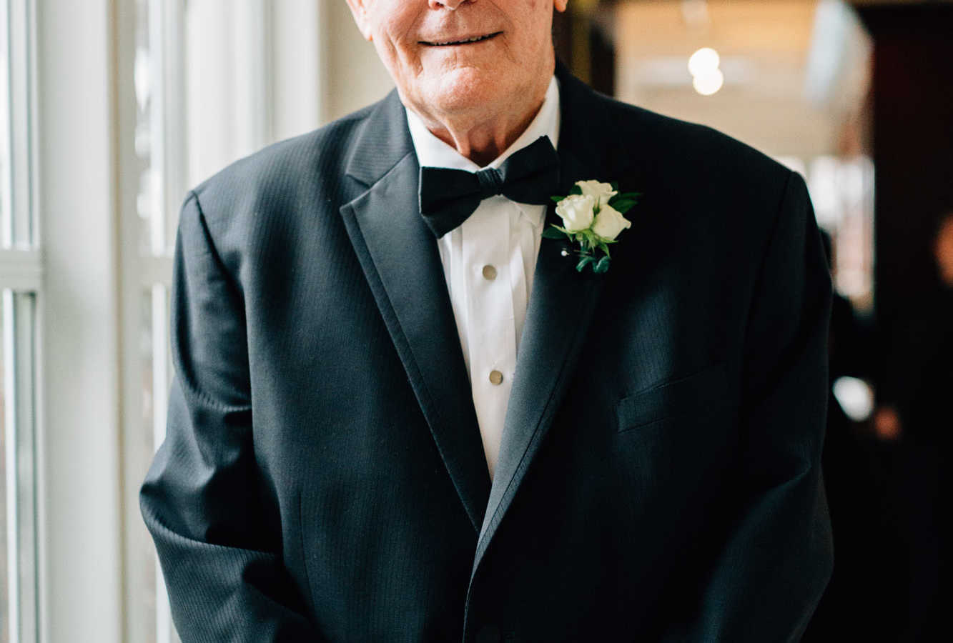 83 year old groom wearing a suit with white boutonniere 