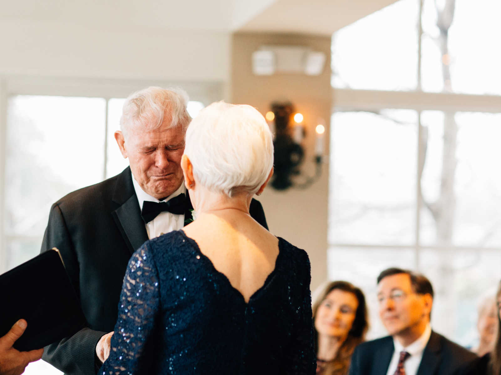 Elderly groom cries while hand in hand with 77 year old bride during ceremony
