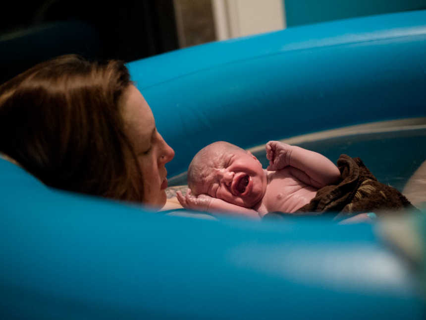 Newborn who was encapsulated in sac at birth cries in moms arms in birthing pool