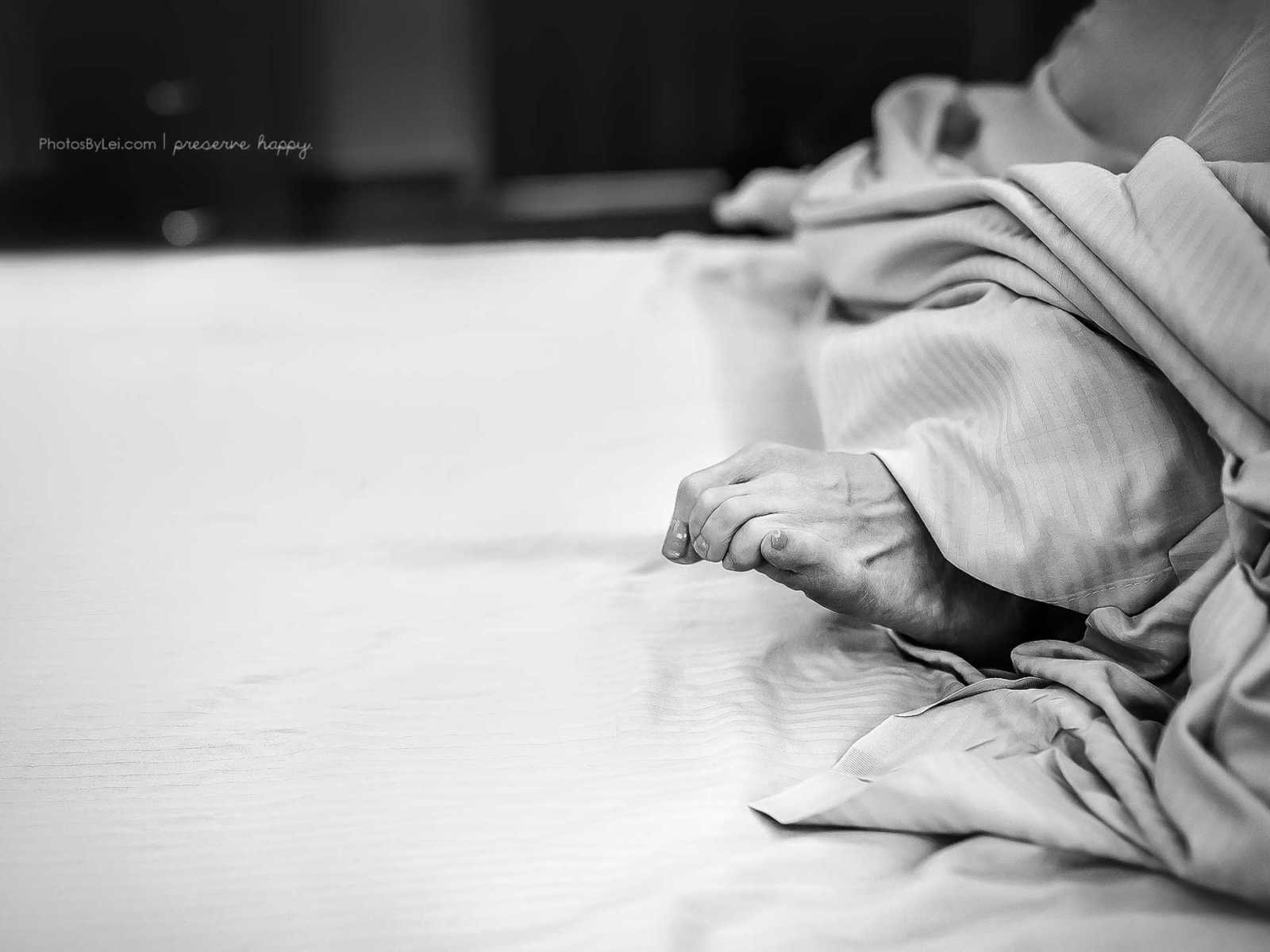 Close up of pregnant womans toes curled over in hospital bed