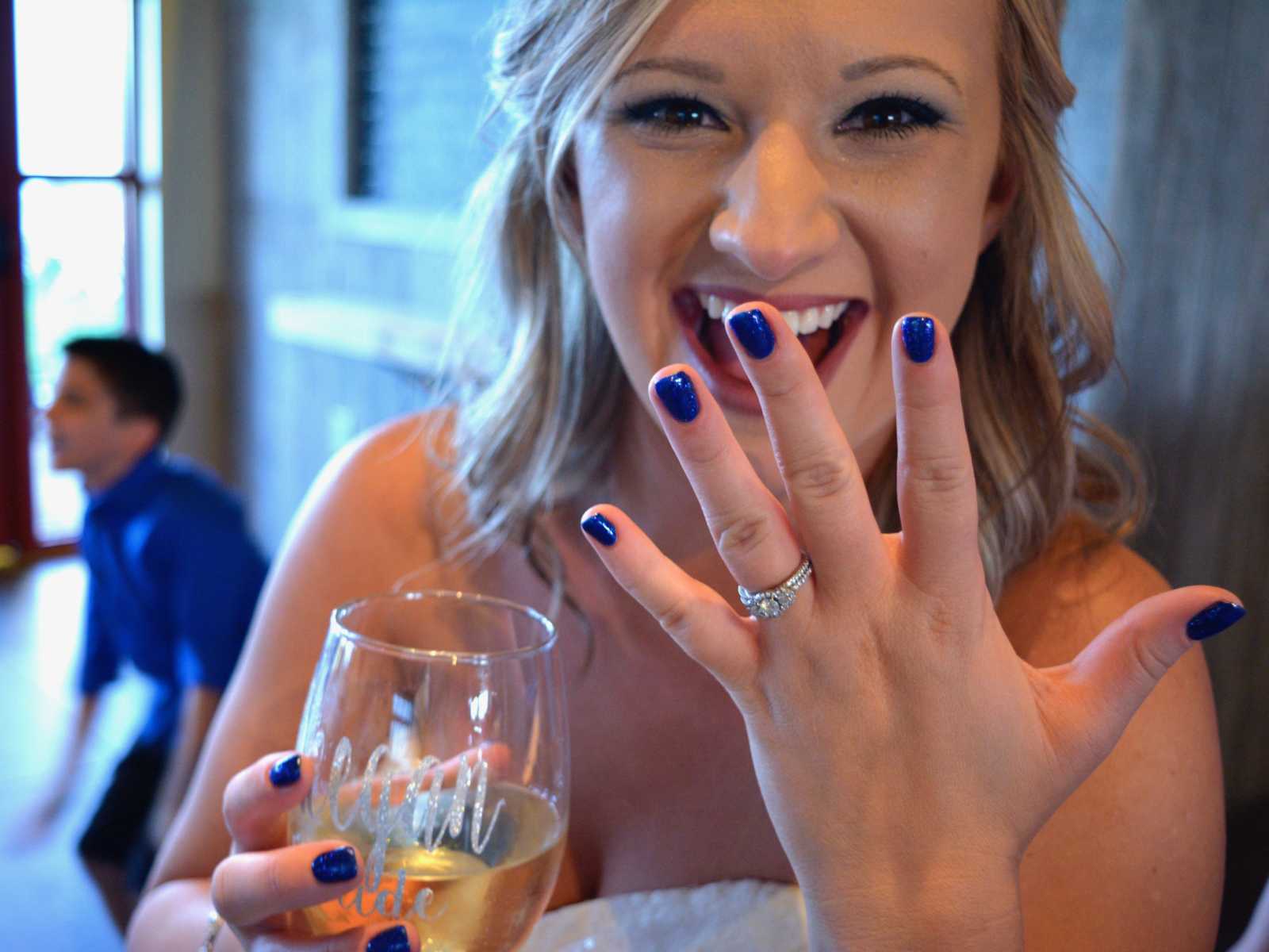 Bride smiling holding up wedding ring that has been passed down through generations