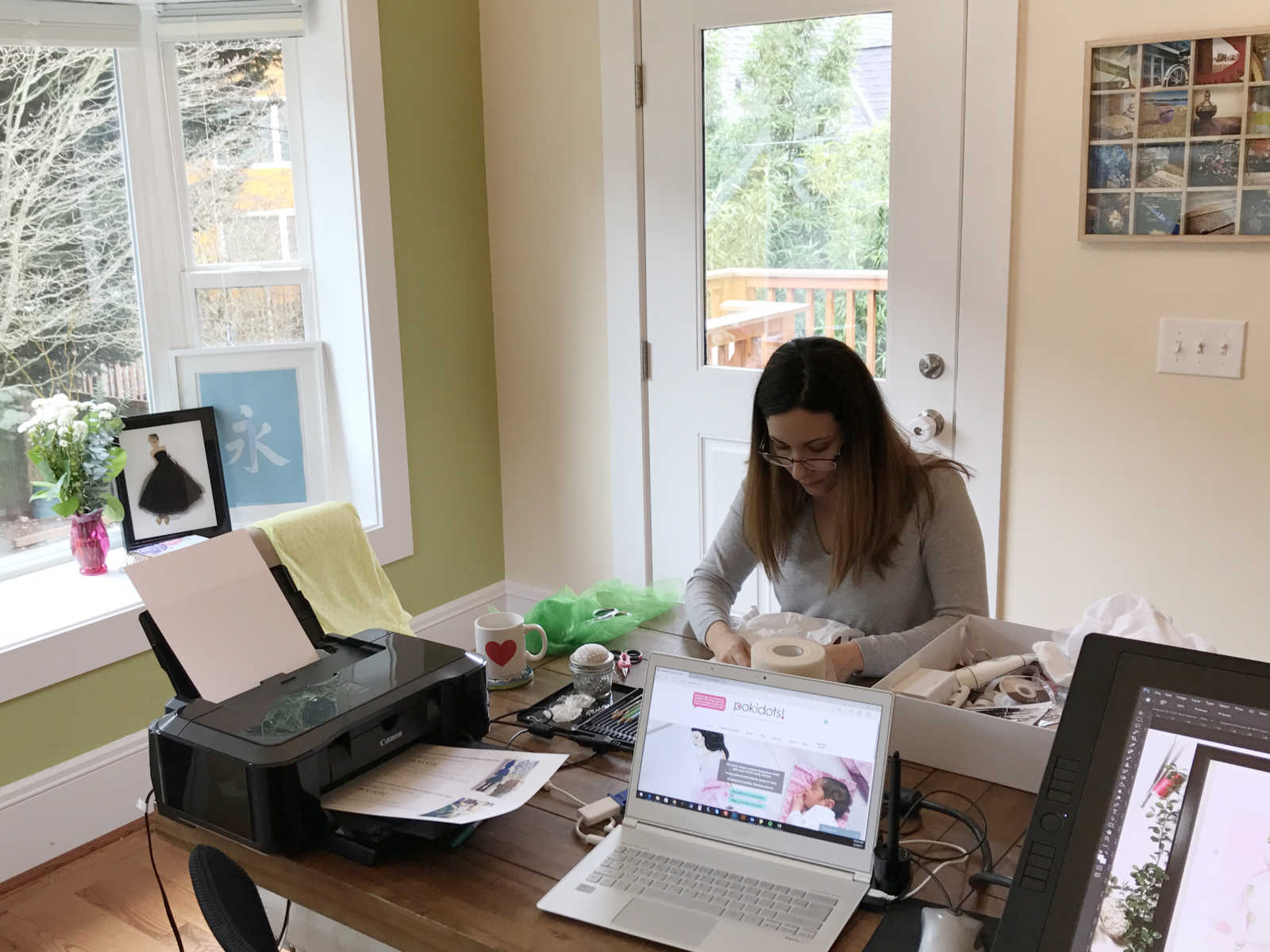 Woman sitting at house at home making paper doll clothes from baby clothes