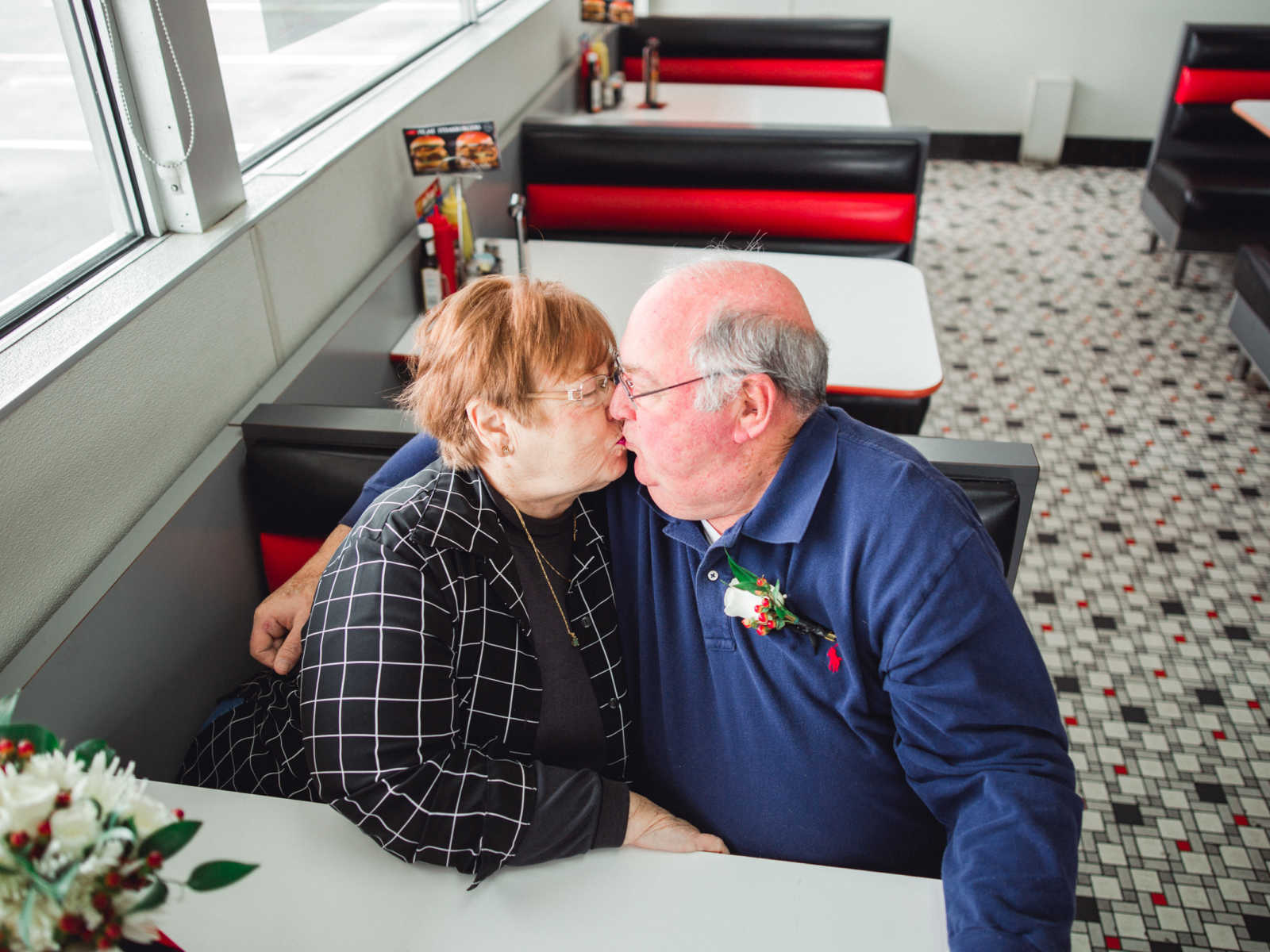 Husband and wife who met at Steak 'n Shake in 1962 kiss in Steak 'n Shake booth