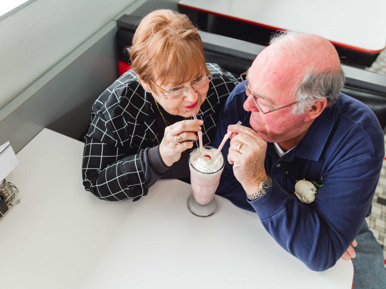 Aerial view of couple who met at Steak 'n Shake in 1962 sharing a milkshake