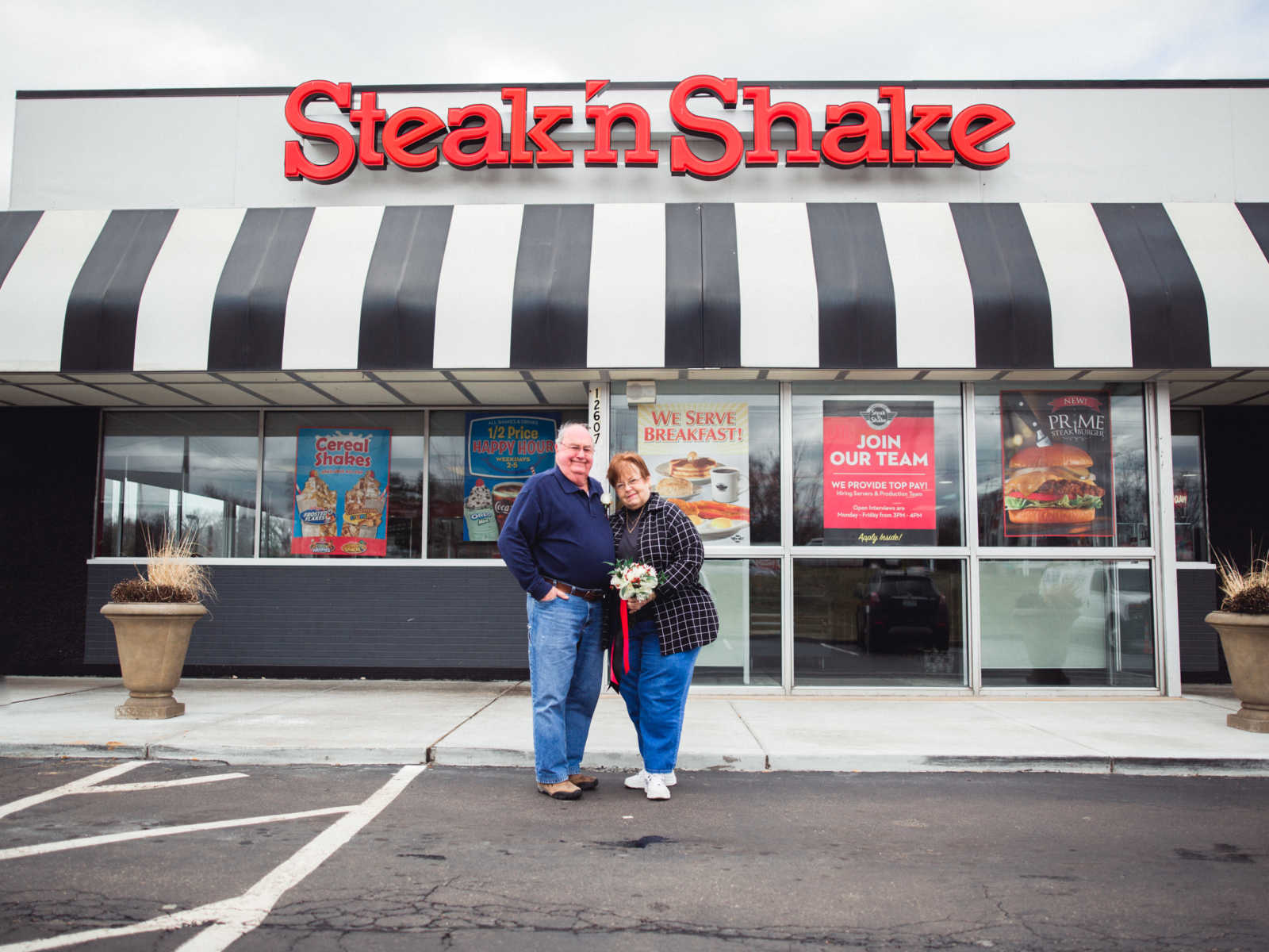Elderly couple stand in front of Steak 'n Shake which is where they met in 1962