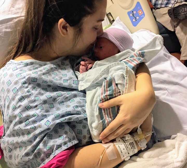 Woman who didn't know she was pregnant kisses newborn on forehead in hospital bed