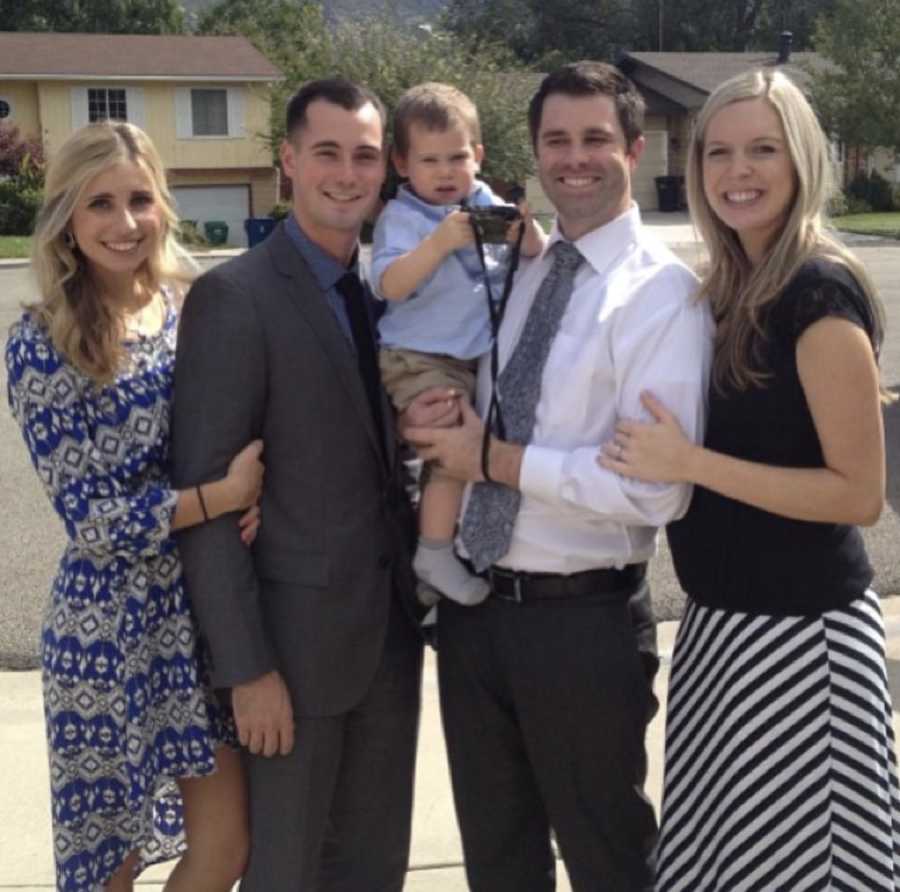 Birth parents and adopted parents stand smiling with their son