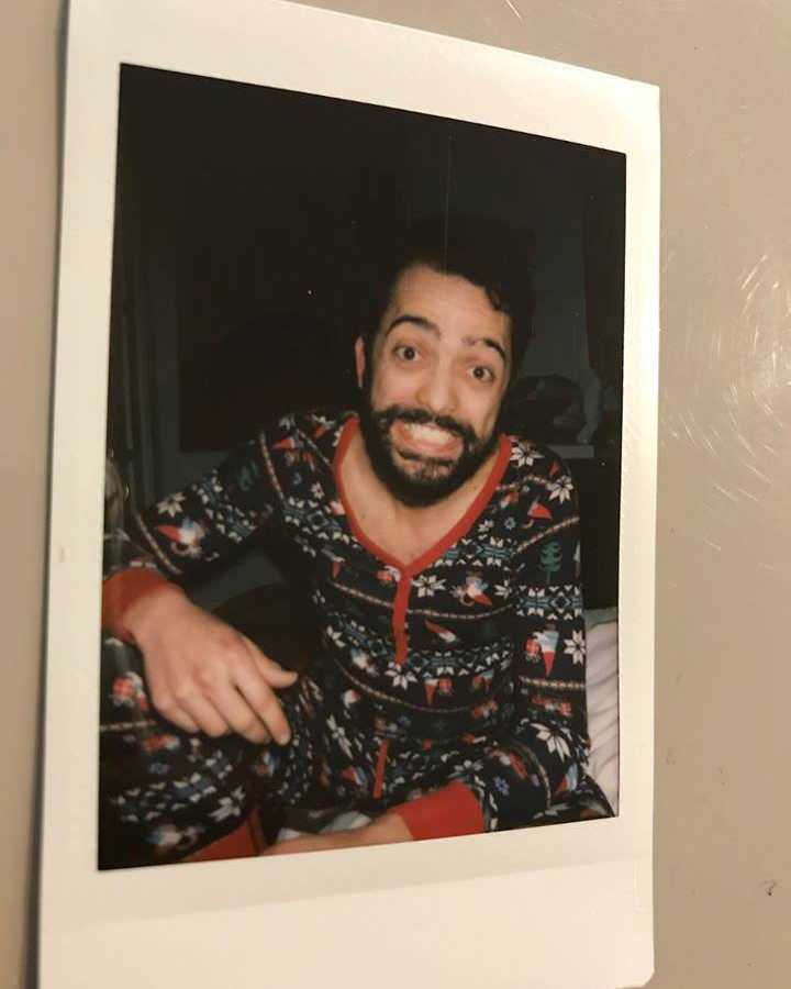 Man smiling in polaroid wearing a onesie
