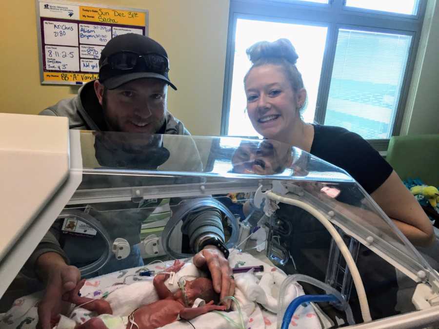 Mother and father who struggled to get pregnant smile of newborn in NICU