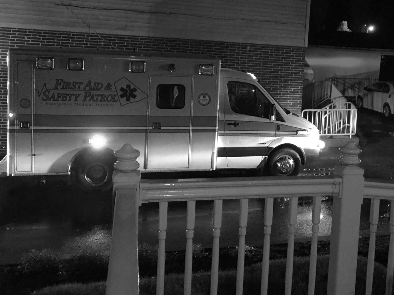 White banister in forefront and ambulance in the background in road