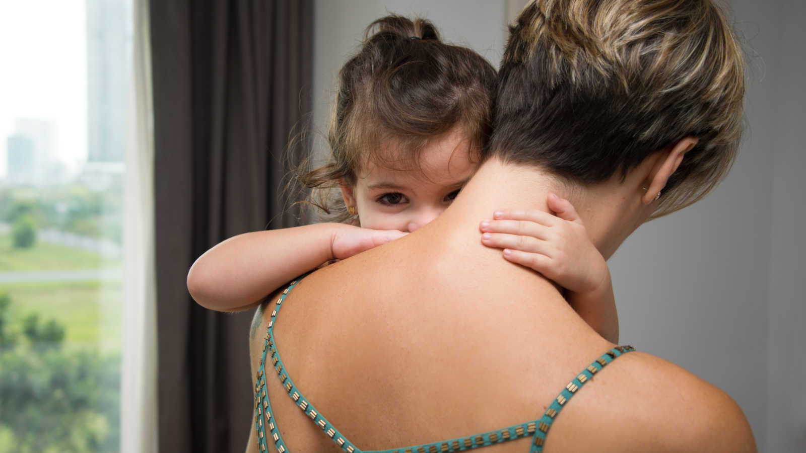 Brunette daughter hugging foster mom's neck