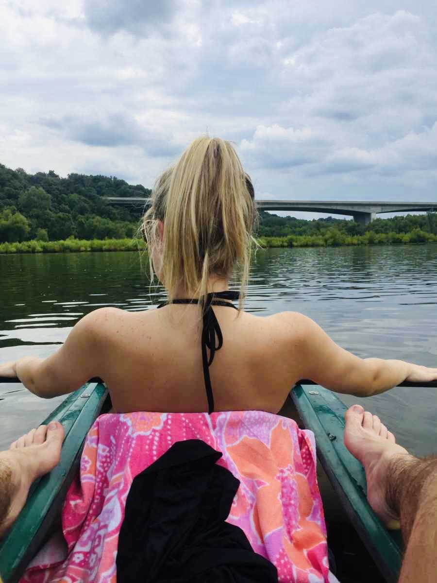 View from man in back of kayak looking at back of girl who shares candid post