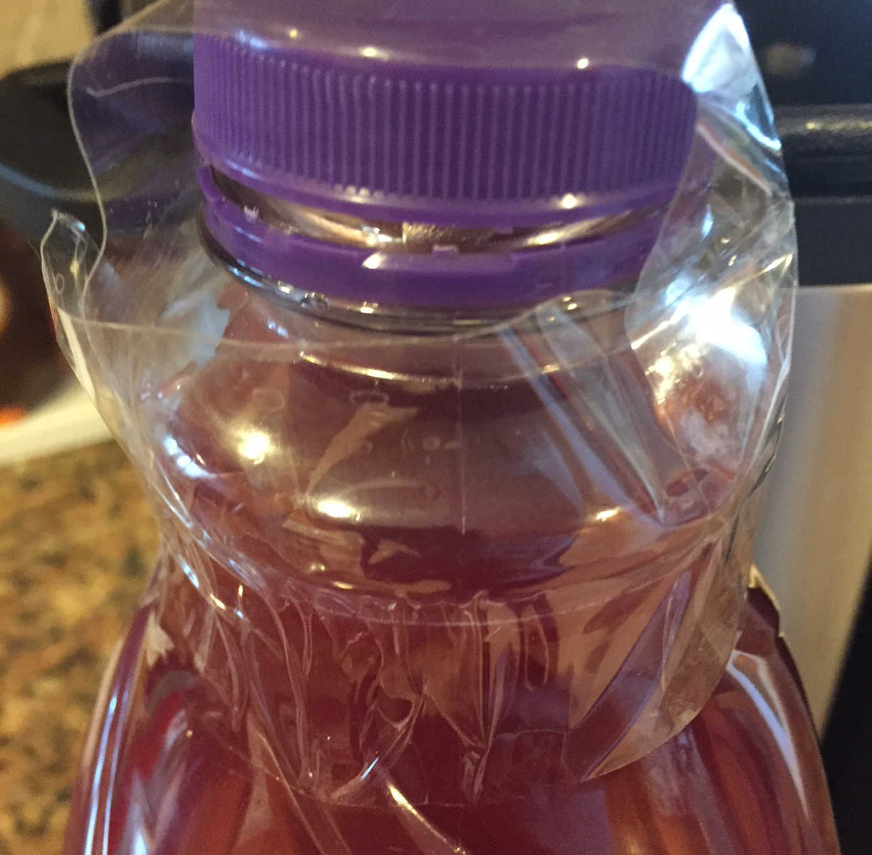 Clear juice bottle filled with red wine covered with clear plastic bag