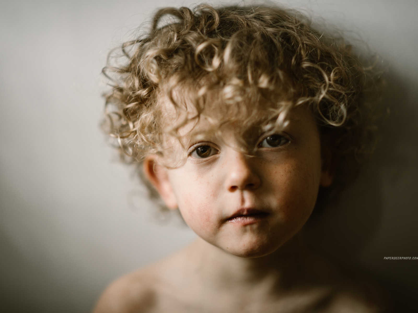 Close up of four year old boy with blonde curly hair who has had two heart surgeries