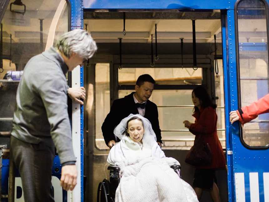 Terminally ill bride in wheelchair being wheeled off gondola as door are held open for her