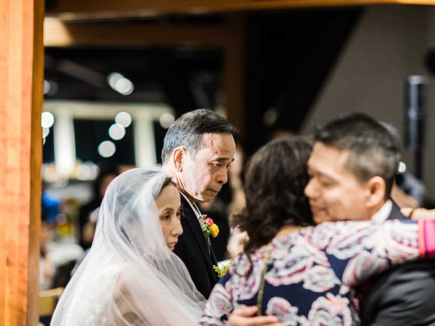 Terminally ill bride stands with father as her mother hugs groom