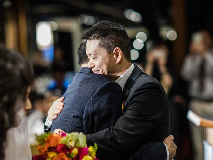 Father and terminally ill bride hugs groom