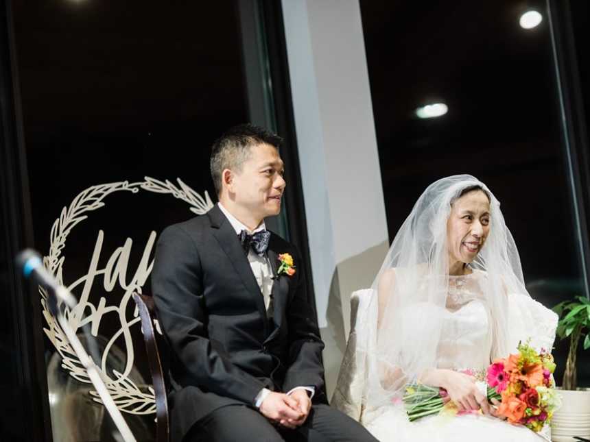 Terminally ill bride sits next to groom as they smile at crowd