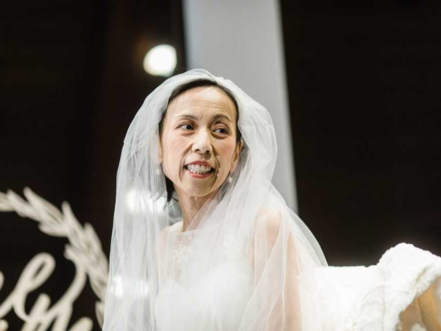 Terminally ill bride smiles in wedding gown and veil over her head
