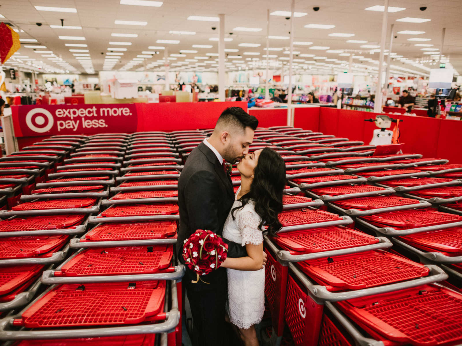 Bride and groom kiss in the middle of shopping carts in Target